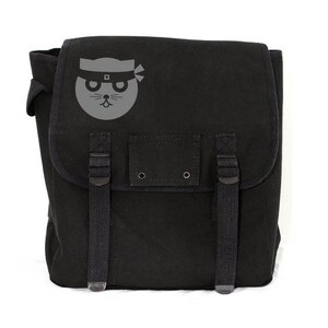 A minimalist black heavyweight canvas backpack featuring a clean, hand-printed graphic of a stylized ninja cat. The pack is displayed in a bright studio setting highlighting its rugged tactical straps and premium textured fabric.
