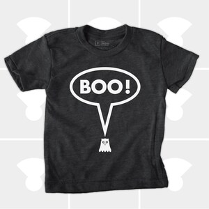 May include: Dark gray t-shirt with a white speech bubble that says "BOO!" and a small ghost illustration. The shirt is made of a soft material and is suitable for children. The shirt is a Halloween-themed apparel.