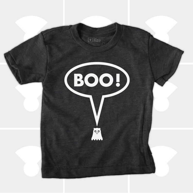 May include: Dark gray t-shirt with a white speech bubble that says "BOO!" and a small ghost illustration. The shirt is made of a soft material and is suitable for children. The shirt is a Halloween-themed apparel.
