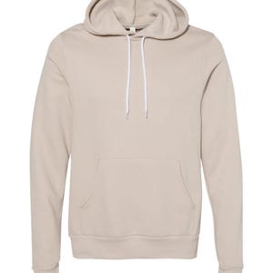 May include: A beige hooded sweatshirt with a front pouch pocket and white drawstrings.