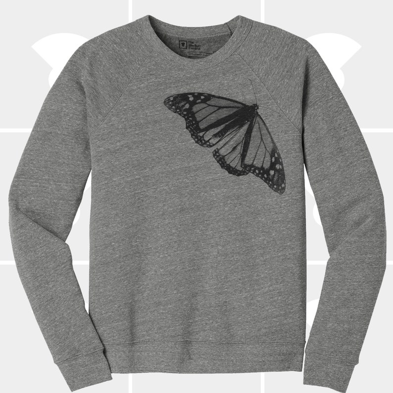 Op de afbeelding: Een grijs sweatshirt met een zwarte vlinderprint op de voorkant.