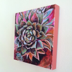May include: A close-up of a painting of a succulent plant with green, purple, and pink leaves. The background is a dark red color.