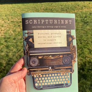 May include: A softcover book with a light green cover featuring a vintage typewriter illustration. The title SCRIPTURIENT (adj) Having a strong urge to write is printed at the top. A note reads: Pictures, prompts, words, and quotes to inspire sensational stories. By Heather Morse Alexander.