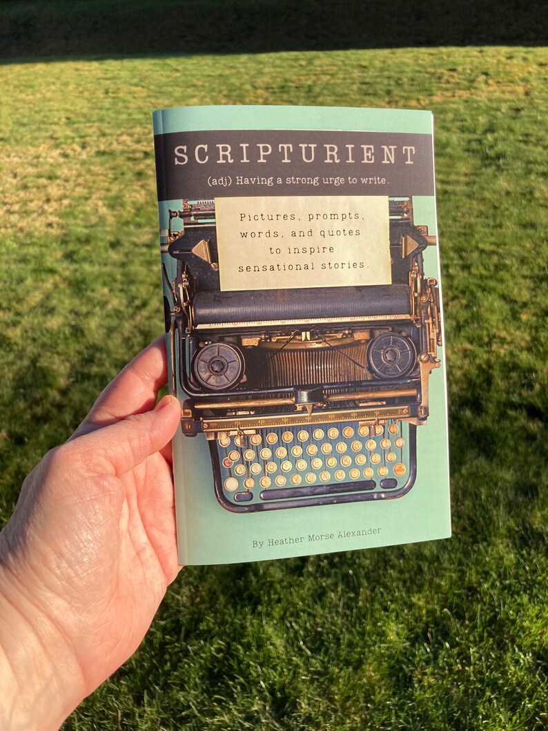May include: A softcover book with a light green cover featuring a vintage typewriter illustration. The title SCRIPTURIENT (adj) Having a strong urge to write is printed at the top. A note reads: Pictures, prompts, words, and quotes to inspire sensational stories. By Heather Morse Alexander.