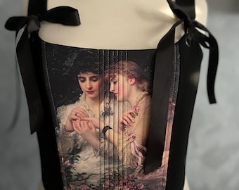 May include: A black corset with adjustable straps and a floral print featuring two women. The print is a vintage style painting of two women in a garden setting.