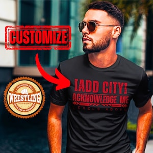 May include: Black t-shirt with red text that reads "I ADD CITY! ACKNOWLEDGE ME LEVELS ABOVE." A "WRESTLING SUPREME" logo is in the lower left corner. The word "CUSTOMIZE" is in a red box at the top.