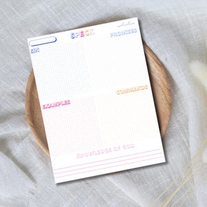 May include: A white notepad with the words "SIN", "SPECK", "PROMISES", "EXAMPLES", "COMMANDS", and "KNOWLEDGE OF GOD" in various colors. The notepad is on a wooden plate and white cloth.