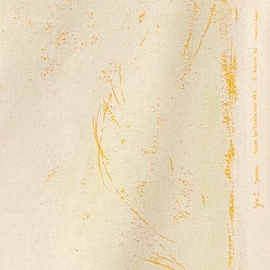 May include: A close-up of a light beige fabric with a subtle texture. The fabric has a faint yellow pattern of lines and dots.