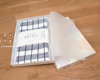 May include: An open white box displaying a folded Japanese fabric with a blue and white checked design. The box also contains a translucent paper cover. The words "MISS MATATABI" and "JAPANESE FABRIC" are visible on the box.