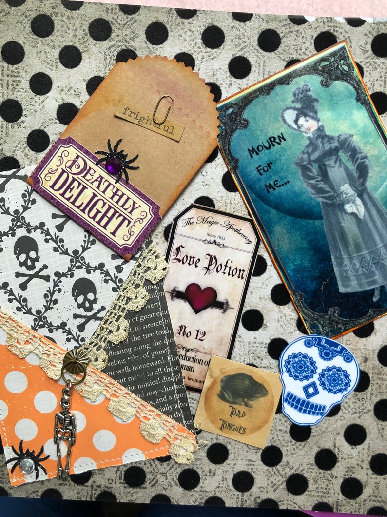 May include: A collage of Halloween-themed paper crafts and ephemera, including a tag that says "Deathly Delight", a tag that says "Love Potion No. 12", a tag that says "Mourn for Me", a tag that says "Toad Tongues", and a skull with a floral design.