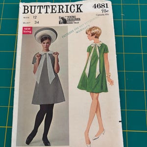 May include: A Butterick 4681 sewing pattern envelope featuring illustrations of a short-sleeved dress with a high neckline and a large bow tie. The envelope displays size 12, bust 34, and includes text such as Young Designer Norma Tullo.