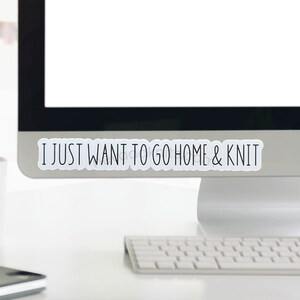 May include: A white computer monitor with a sticker on the bottom edge that says "I just want to go home & knit".