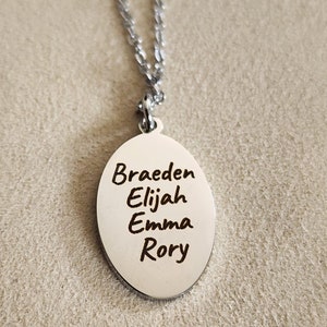 May include: Silver necklace with an oval pendant engraved with the names Braeden, Elijah, Emma, and Rory.