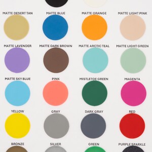 May include: A color chart featuring 24 matte finish circles in various colors. Colors include black, white, tan, blue, orange, pink, lavender, brown, teal, green, sky blue, pink, mistletoe green, magenta, yellow, gray, dark gray, red, bronze, silver, green, and purple sparkle.