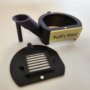 Könnte beinhalten: Schwarz-goldenes 3D-gedrucktes Vogelhaus mit abnehmbarem Frontpaneel und einem Schild mit der Aufschrift "Puff's Place".