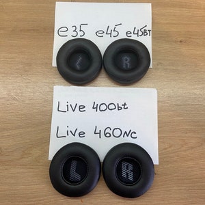 May include: Four pairs of black ear cushions for headphones. The cushions are labeled with the letters "L" and "R" for left and right. The labels are written on white paper with the text "e35 e45 e45bt Live 400bt Live 460nc".