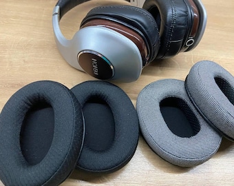 May include: Four replacement ear pads for headphones. Two are black with a textured surface and two are gray with a textured surface.