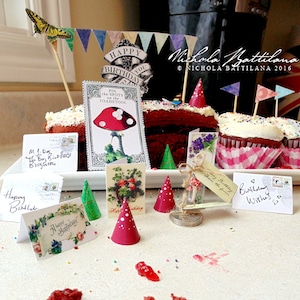 Peut inclure: Un gâteau rouge velours avec un glaçage blanc et des pépites, décoré d'une bannière Joyeux Anniversaire, d'un papillon et d'un champignon. Il y a aussi de petites miettes de gâteau rouge velours sur la table.