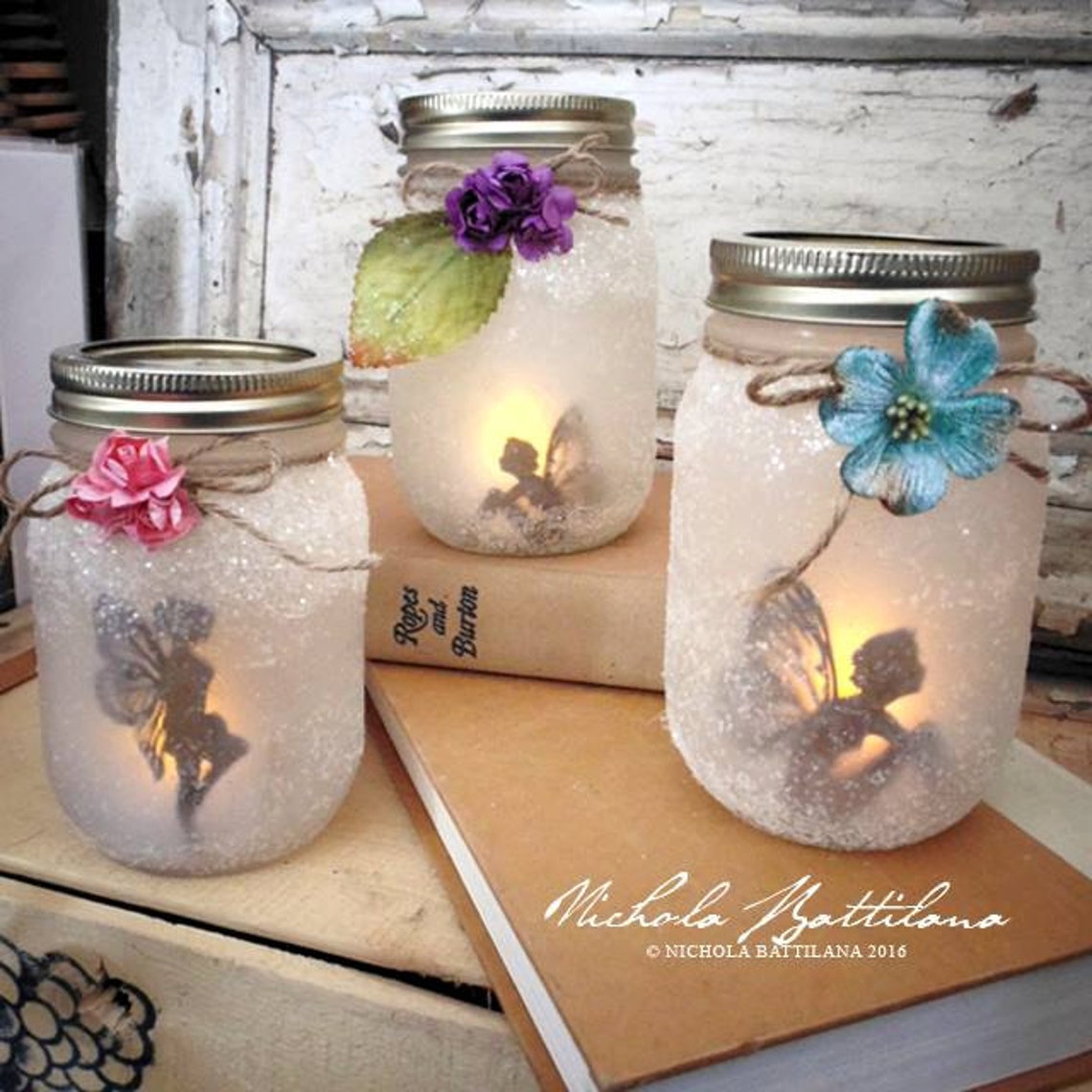 Few fairies in a jar lit and stand on a couple of books