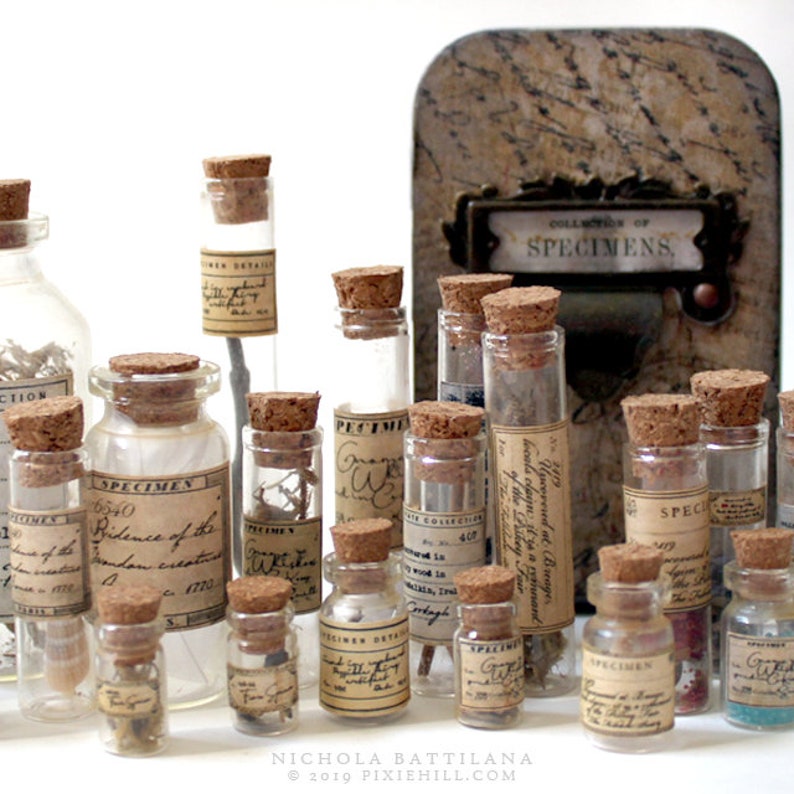 May include: A collection of small glass bottles with cork stoppers, each filled with different items and labeled with handwritten text. The labels include words like "Specimen", "Evidence of the London Creations", and "Upcovered at Breager". The bottles are arranged on a table with a small wooden box labeled "Collection of Specimens".