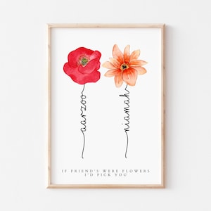 Puede incluir: Una impresión enmarcada con una ilustración de acuarela de dos flores, una amapola roja y una flor naranja. Las flores tienen nombres escritos debajo, "Aimee" y "Niamh". El texto debajo de las flores dice "Si los amigos fueran flores, te elegiría."