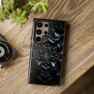 May include: A black phone case with a geometric pattern and a camera lens cutout. The case has a glossy finish and a black background.