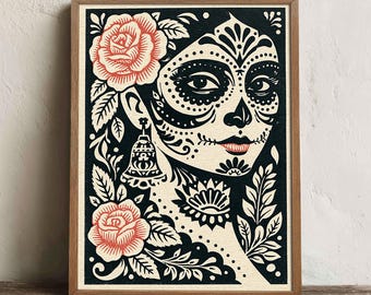 May include: A framed wall art print featuring a stylized illustration of a face with intricate black and white sugar skull makeup, accented by two coral-colored roses and a bell-shaped earring, set against a dark background in a wooden frame.