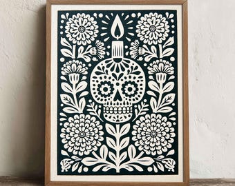 May include: A framed wall art print featuring a black and white graphic illustration of a sugar skull with a lit candle on top, surrounded by symmetrical floral patterns and leaves. The artwork is encased in a light brown wooden frame.
