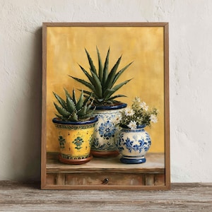 May include: A framed painting featuring three potted plants against a yellow background. Two pots are decorated with blue floral patterns, while the third is yellow with green accents. The plants include two spiky succulents and a small white flower arrangement.