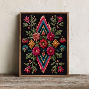 Puede incluir: Una pieza de bordado enmarcada que presenta un patrón geométrico central en forma de diamante en tonos vibrantes de rosa, turquesa y naranja, rodeado de motivos florales simétricos en rojo, amarillo y rosa con hojas verdes sobre fondo negro.