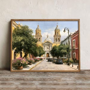 May include: An oil painting depicting a sunlit street scene leading to a large colonial-style church with two bell towers and a central dome. Lush green trees, pink flowering bushes, parked cars, and a tall street lamp line the paved road.