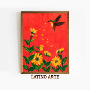 Puede incluir: Una pintura enmarcada de un colibrí con plumas verdes y rojas, volando sobre un campo de girasoles amarillos sobre un fondo rojo. La pintura se titula "LATINO ARTE".