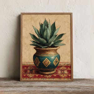 Può includere: Una stampa artistica incorniciata raffigurante una pianta di agave verde in un vaso di ceramica color ottanio con motivi geometrici a rombi gialli. Il vaso poggia su un tessuto rosso e giallo su uno sfondo beige strutturato.