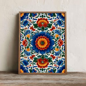 Puede incluir: Una impresión floral enmarcada con un diseño simétrico y vibrante. La obra de arte presenta grandes flores estilizadas en tonos de azul, naranja y amarillo sobre un fondo blanco. El marco es de madera y la estética general es decorativa.