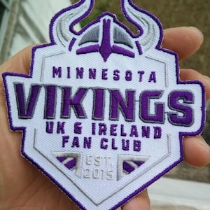 May include: White and purple embroidered patch featuring the Minnesota Vikings logo. The patch includes a helmet with horns, the words "Minnesota Vikings" and "UK & Ireland Fan Club", and the text "Est. 2015".