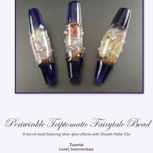 Puede incluir: Tres cuentas de vidrio con un efecto de vidrio plateado y un color azul periwinkle. Las cuentas tienen forma de barril y un diseño de doble hélice. Las cuentas están sobre una superficie gris. Periwinkle Triptomatic Fairytale Bead. Tutorial. Level: Intermediate. By Michele Coletti. Photography by Mike Vasquez and Michele Coletti. ©2016