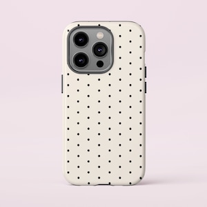 May include: A white phone case with a black polka dot pattern. The case has a raised camera bump with three black camera lenses.