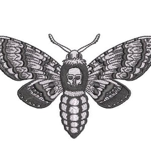 May include: An embroidered design of a moth featuring a skull pattern on its thorax. The moth has detailed wings with dark grey and white stitching, two antennae, and a segmented abdomen, all rendered in a monochromatic black and white color scheme.