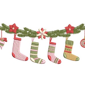 Könnte beinhalten: Eine Girlande aus grünen Kiefernästen mit roten Weihnachtssternen und weißen Blüten hängt mit vier Strümpfen. Zwei Strümpfe sind rosa mit weißen und grünen Streifen, einer ist grün mit weißen und rosa Streifen und einer ist beige mit grünen und weißen Streifen. Ein rot-weißes Ornament hängt an der Girlande.