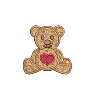 May include: An embroidered patch of a seated teddy bear with a golden glittery texture, featuring a dark brown stitched outline, two round eyes, a small nose, and a prominent red glittery heart centered on its chest against a plain background.