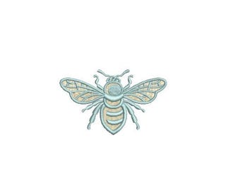 May include: An embroidered bee patch featuring light blue thread for the outline and body segments, with a cream-colored fill pattern within the wings and abdomen. The design displays a detailed insect with six legs, two antennae, and wings.