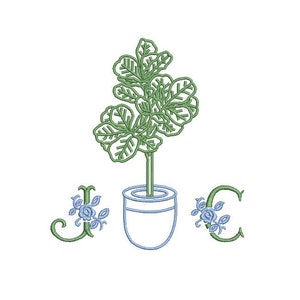May include: A green plant with leaves in a white pot with blue flowers on the letters J and C.
