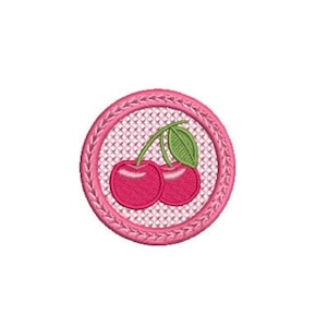 Peut inclure: Un écusson brodé circulaire représentant deux cerises rouge vif avec des tiges vertes et une feuille verte. Les cerises sont centrées sur un fond blanc à motifs croisés, entourées d'une bordure rose épaisse et texturée avec un motif tressé.
