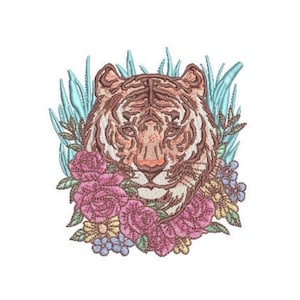 May include: An embroidery design featuring a tiger head centered among pink roses, small yellow and blue flowers, and light blue foliage. The tiger is rendered in shades of brown and tan with dark stripes, surrounded by detailed floral elements.