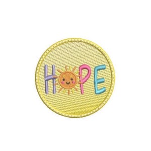 May include: A circular embroidered patch with a yellow background and a stitched border. The word HOPE is spelled out in colorful letters, with a smiling orange sun icon replacing the letter O. The letters H, P, and E are purple, pink, and blue.