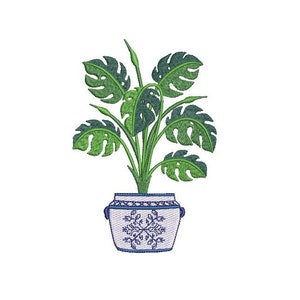 Pode incluir: Design bordado de uma planta em vaso com folhas grandes, verdes e divididas. A planta está num vaso branco com padrões florais azuis e pegas. O desenho está sobre um fundo branco.