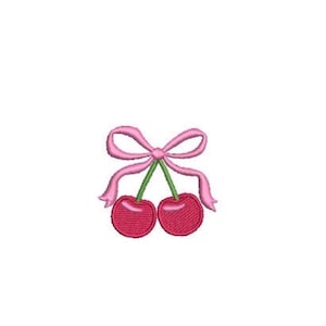 Puede incluir: Un parche bordado que muestra dos cerezas de color rojo brillante con tallos verdes, atadas en la parte superior con un lazo de cinta rosa claro. El diseño utiliza puntadas detalladas para crear textura y reflejos en la fruta y el lazo.