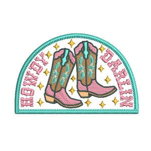 May include: A turquoise and white embroidered patch with pink cowboy boots and the text "Howdy Darlin".