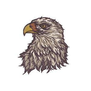 Könnte beinhalten: Nahaufnahme eines gestickten Weißkopfseeadlerkopfes mit gelbem Schnabel und braunem Auge. Die Federn des Adlers sind eine Mischung aus Braun und Weiß.