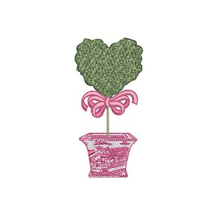 May include: A heart-shaped topiary tree with a pink bow tied around the trunk, potted in a pink and white patterned planter.